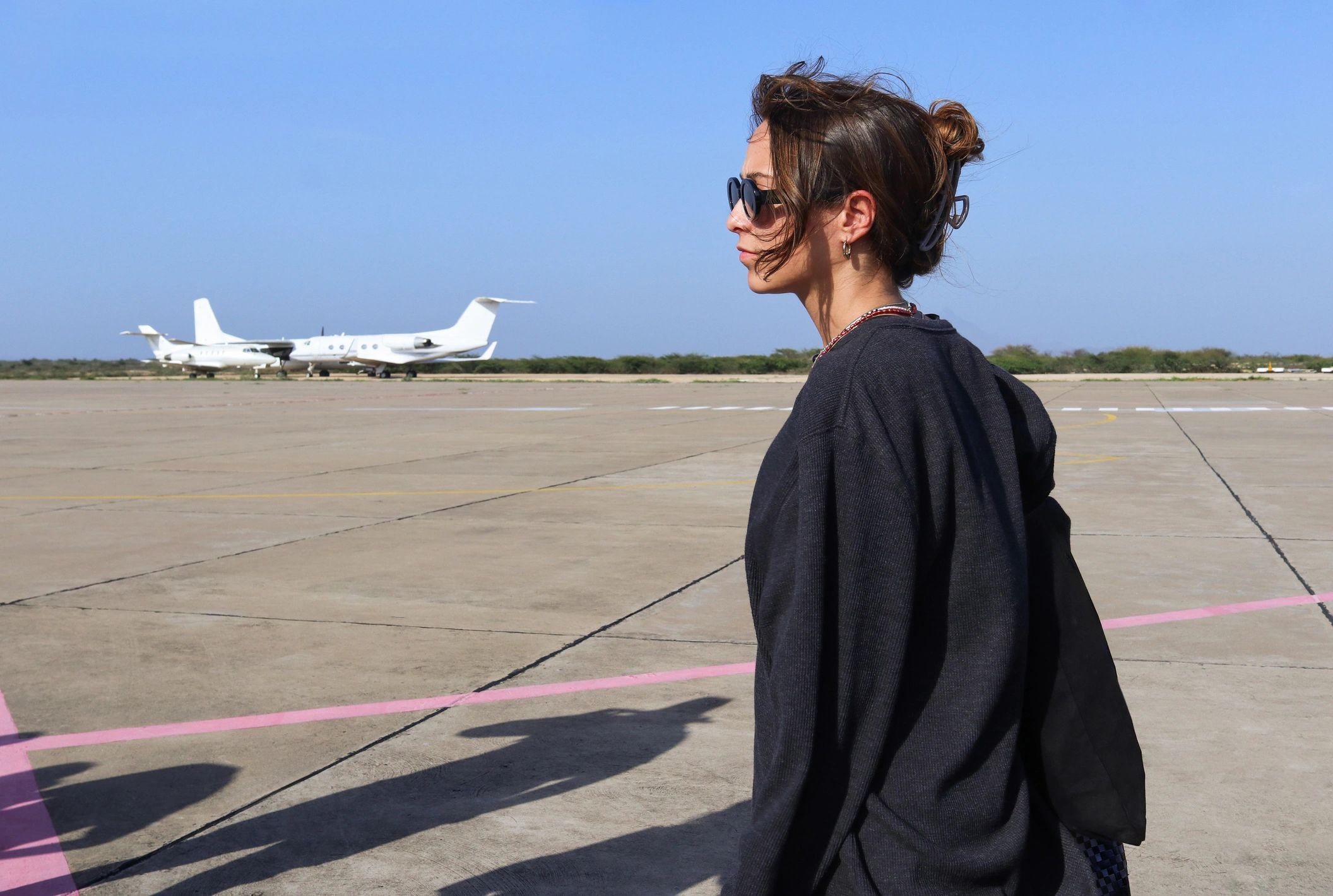 Traveler standing on an airport tarmac looking toward an aircraft